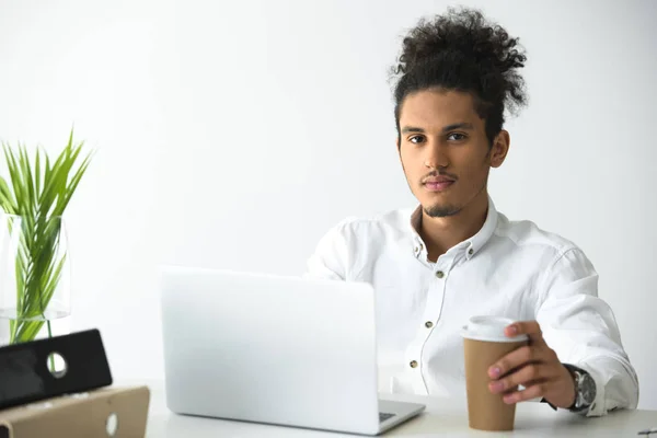 Красивий молодий афроамериканський бізнесмен використовує ноутбук і дивиться на камеру — стокове фото