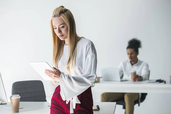 Schöne junge blonde Geschäftsfrau mit digitalem Tablet im Büro — Stockfoto