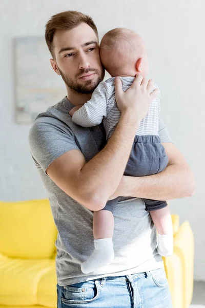 Young father holding infant baby boy at home — Stock Photo