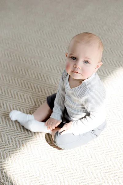 Adorable little baby boy sitting on floor — Stock Photo