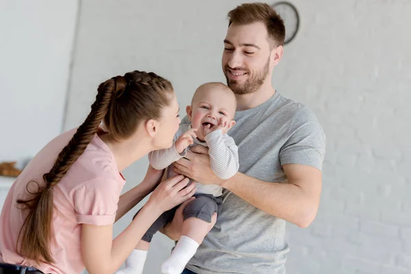 Feliz familia jugando con bebé niño - foto de stock