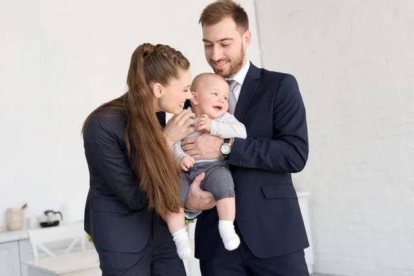 Felice coppia d'affari che tiene il figlio a casa — Foto stock