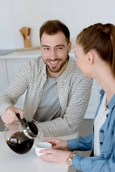 Mari souriant verser du café pour avec femme sur la cuisine le matin — Photo de stock