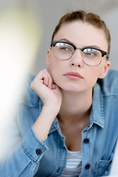 Портрет вдумливої молодої жінки в окулярах — стокове фото