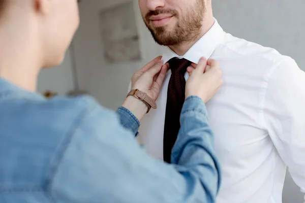 Femme portant une cravate sur homme d'affaires à la maison — Photo de stock