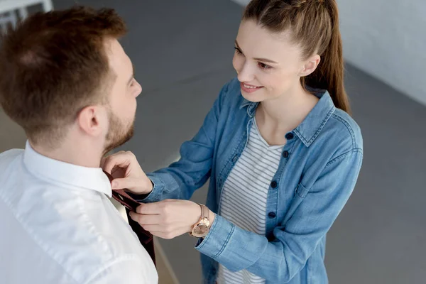 Wife wearing a tie on her husband at home — Stock Photo