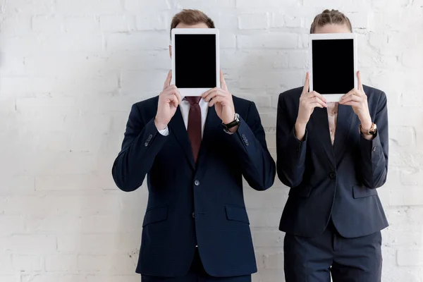 Предприниматели в формальной одежде держат цифровые планшеты с пустыми экранами — стоковое фото