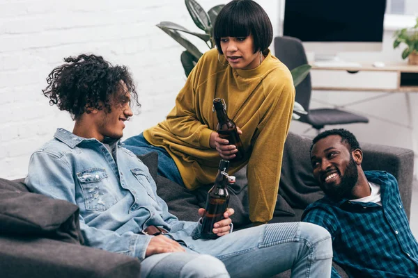 Group of multicultural young friends with bottles of beer talking to each other — Stock Photo