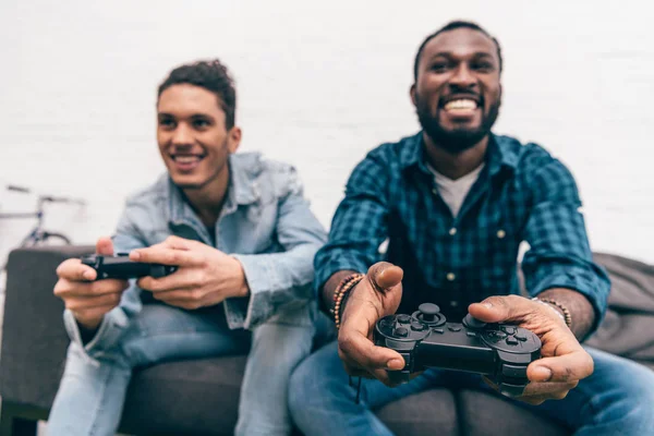 Багатоетнічні чоловіки друзі з джойстиками грають у відео гру — стокове фото