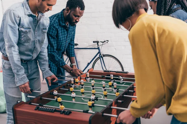 Seitenansicht multiethnischer Freunde beim Tischkicker — Stockfoto