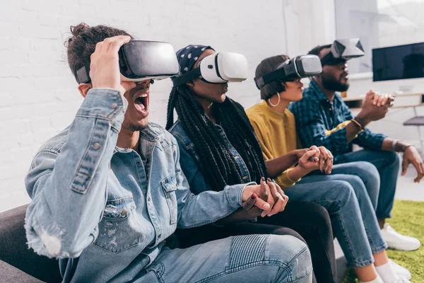 Group of young multicultural friends using virtual reality headsets — Stock Photo