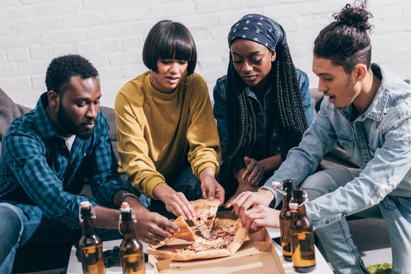 Gruppe junger multiethnischer Freunde greift nach Pizza — Stockfoto