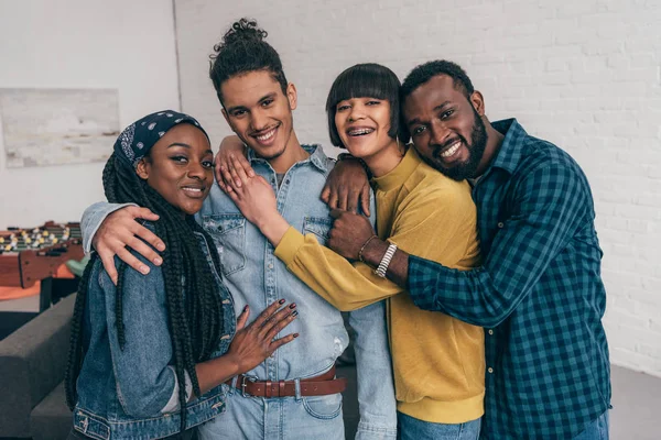 Retrato de un joven grupo sonriente de amigos multiétnicos abrazándose - foto de stock