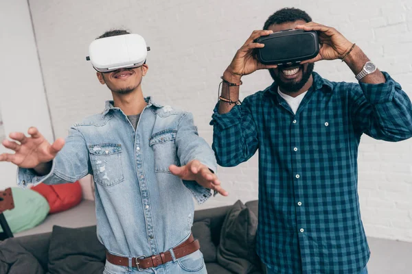 Lächelnde junge männliche Freunde mit Virtual-Reality-Headsets — Stockfoto