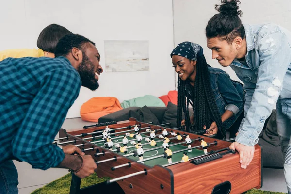 Multicultural young friends playing table football — Stock Photo