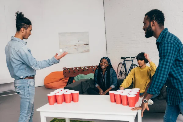 Groupe multiculturel d'amis jouant au bière pong à table — Photo de stock