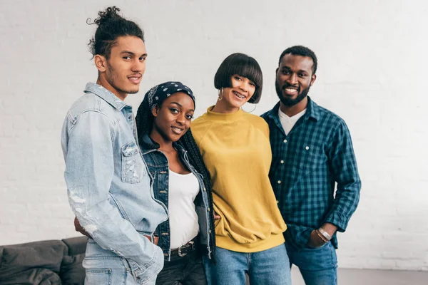 Портрет улыбающейся группы мультикультурных друзей, стоящих в помещении — стоковое фото