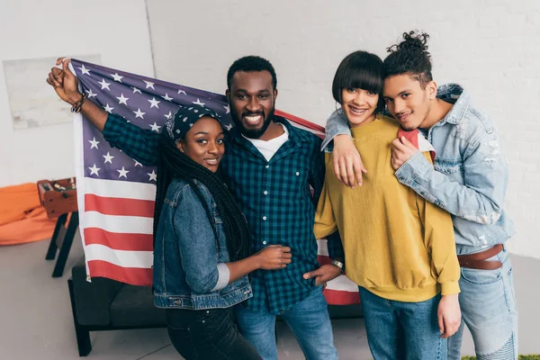 Four multiethnic friends standing with flag of USA — Stock Photo