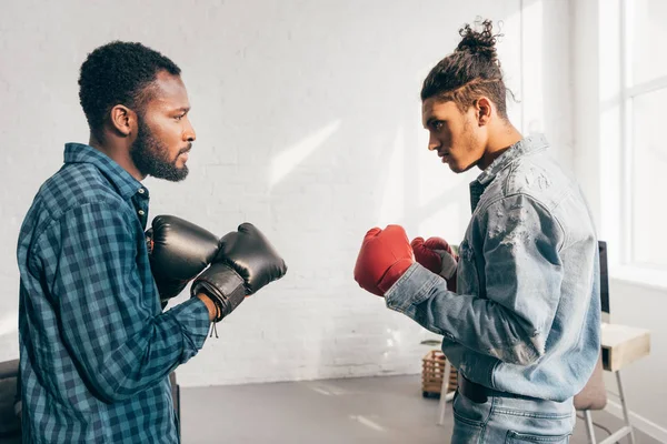 Vista lateral de dois jovens multiculturais boxe com luvas — Fotografia de Stock