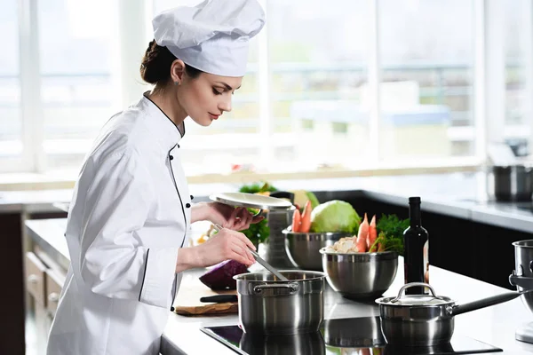 Femme chef cuisinier cuisinière dans la casserole sur cuisinière — Photo de stock