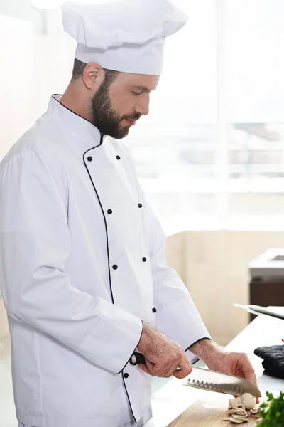 Chef professionista che taglia funghi sul tavolo della cucina — Foto stock