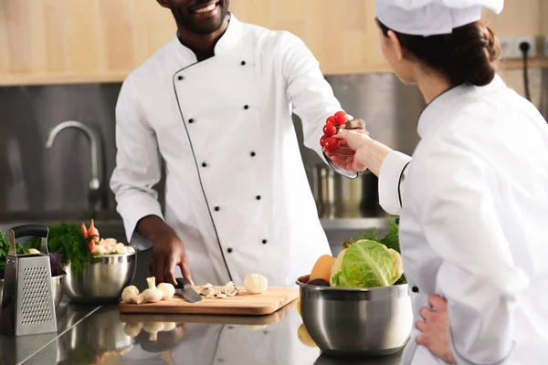 Equipe multirracial de cozinheiros compartilhando ingredientes culinários — Fotografia de Stock