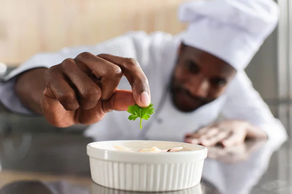 Vista de perto do chef americano africano enfeite prato na cozinha do restaurante — Fotografia de Stock