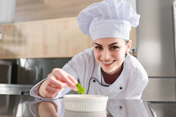 Chef femenino guarnición plato en la cocina del restaurante - foto de stock