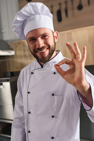 Sorrindo chef masculino mostrando sinal ok na cozinha — Fotografia de Stock