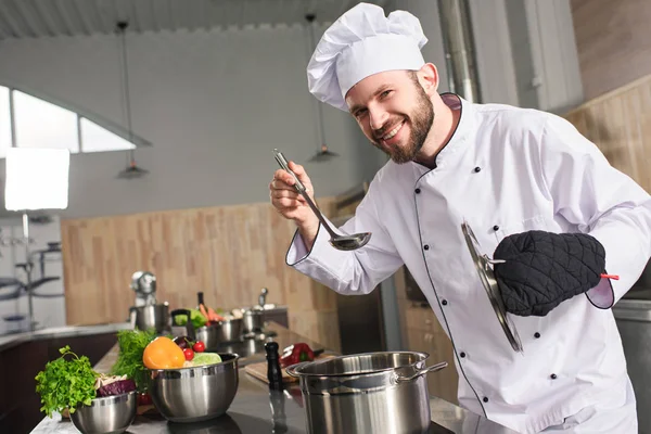 Männerkoch verkostet Gericht in Restaurantküche — Stockfoto