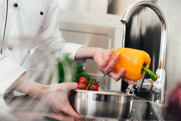 Cropped view of female cook washing vegetables — Stock Photo