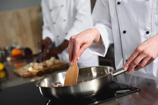 Close-up view of female chef cooking on frying pan — Stock Photo