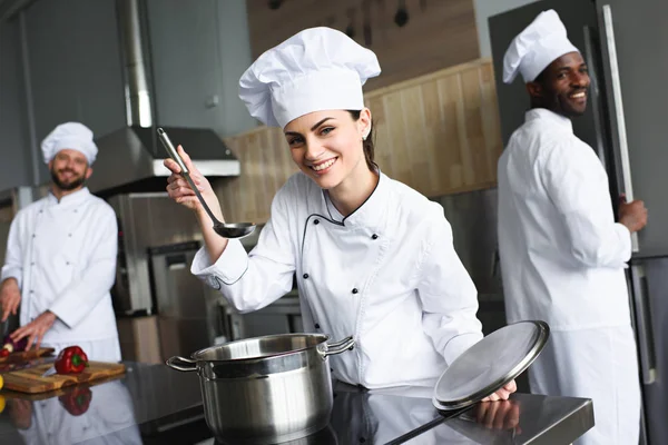 Plato degustación de chef femenina por su equipo multirracial - foto de stock