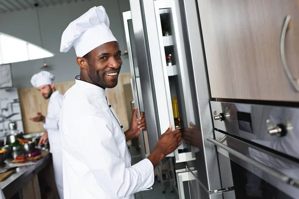 Équipe multiraciale de cuisiniers travaillant sur la cuisine de restaurant professionnel — Photo de stock