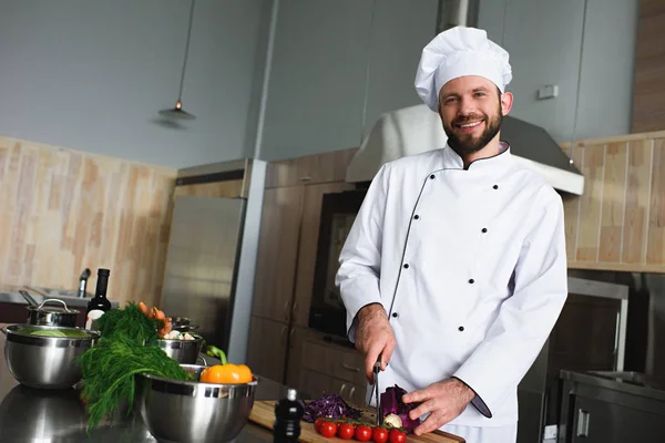 Profi-Koch schneidet Gemüse auf Küchentisch — Stockfoto