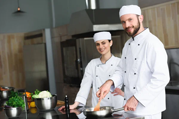 Chefs frying vegetables on frying pan at restaurant kitchen — Stock Photo