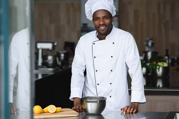 Bellissimo chef afro-americano in piedi vicino al bancone della cucina al ristorante cucina — Foto stock