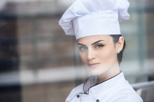 Atractivo chef mirando a la cámara en la cocina del restaurante - foto de stock