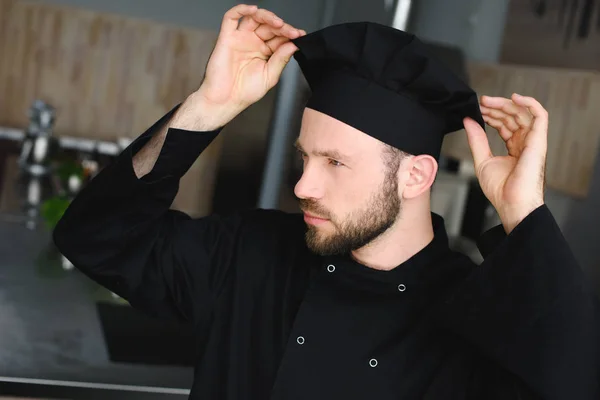 Guapo chef con sombrero en la cocina del restaurante - foto de stock