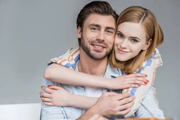 Portrait of young woman hugging boyfriend from behind — Stock Photo