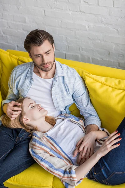 Young attractive woman with closed eyes laying on boyfriend knees — Stock Photo