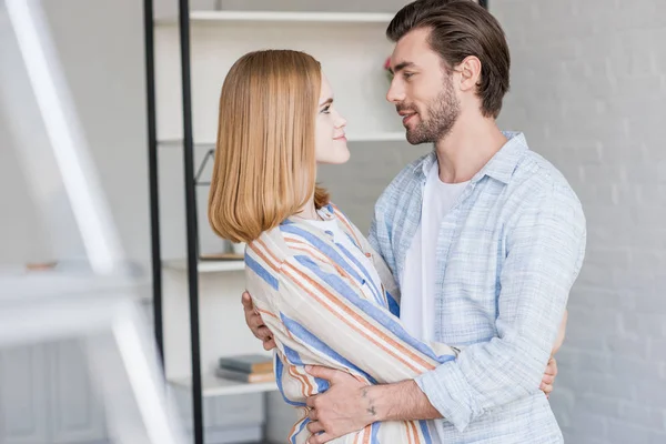 Side view of young smiling couple embracing each other — Stock Photo