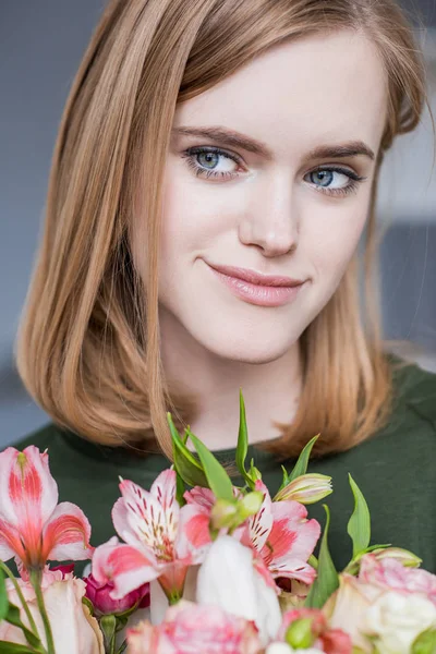 Portrait of young woman with bouquet of alstroemeria — Stock Photo