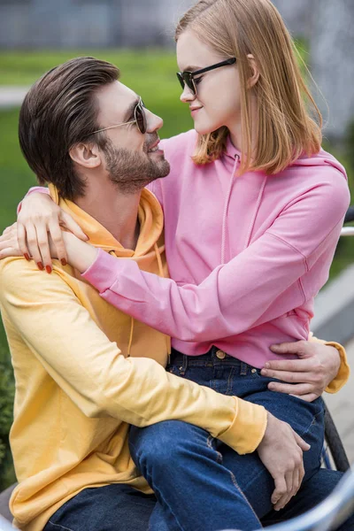 Uomo in occhiali da sole che abbraccia ragazza elegante in occhiali da sole — Foto stock