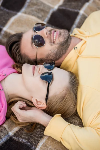 Sonriente pareja en gafas de sol puesta en cuadros - foto de stock