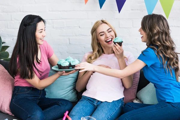 Amigos multiculturais e mulher grávida comendo cupcakes na festa do bebê — Fotografia de Stock