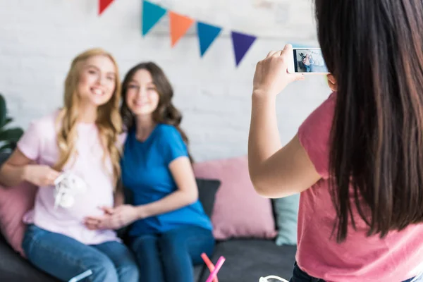 Женщина фотографируется со смартфоном друзей на детской вечеринке — стоковое фото
