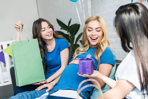Amigos regalos de regalos a la mujer embarazada en la fiesta de bebé - foto de stock