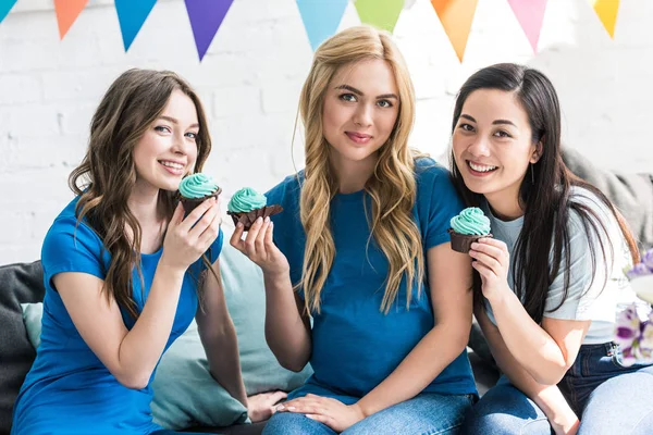 Amigos multiculturales y mujeres embarazadas con cupcakes en la fiesta del bebé - foto de stock