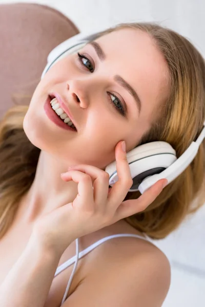 Alegre chica atractiva escuchando música con auriculares - foto de stock